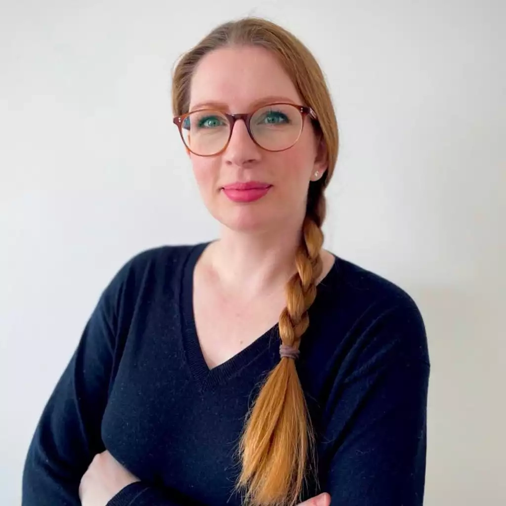 Eine frau mit brille und einem schwarzen pullover.