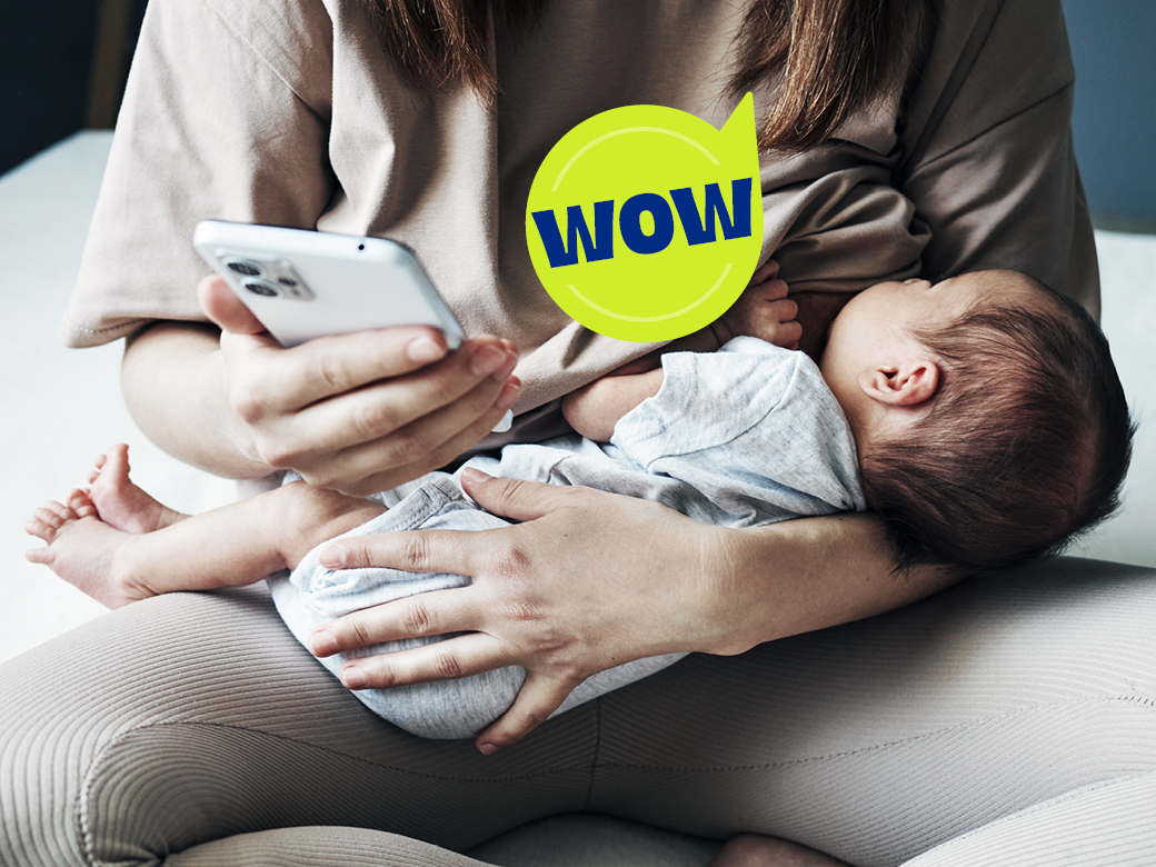 Frau stillt Baby und schaut dabei aufs Handy - Sprechblase wow