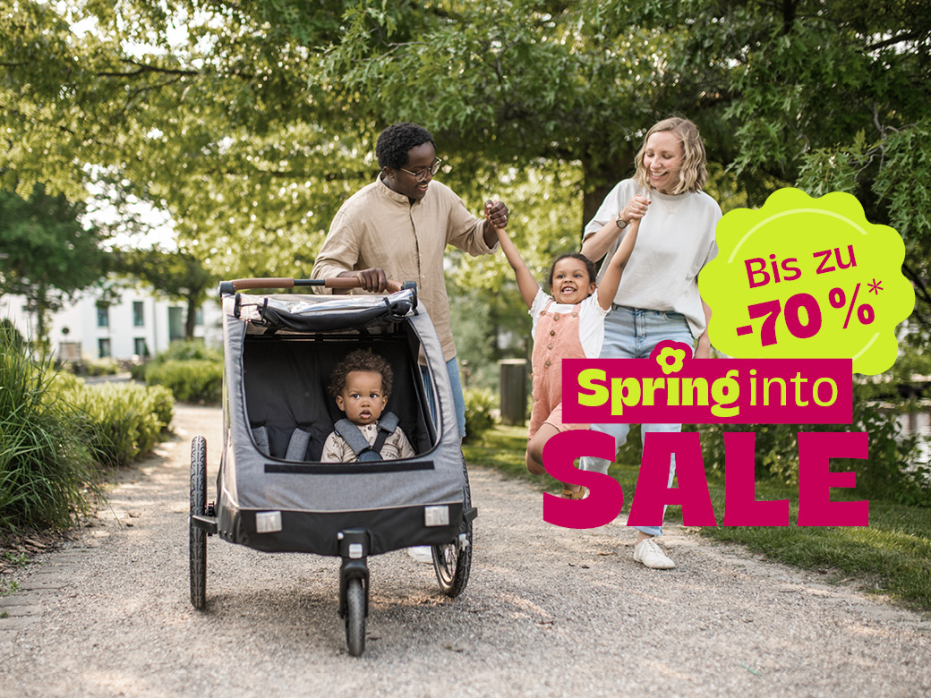 Familie im Park mit springendem Kind. Bis zu 70%. Spring into Sale.