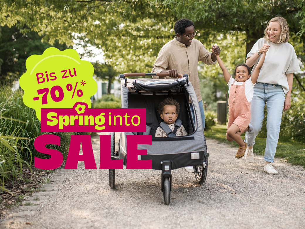 Familie im Park mit springendem Kind. Bis zu 70%. Spring into Sale.