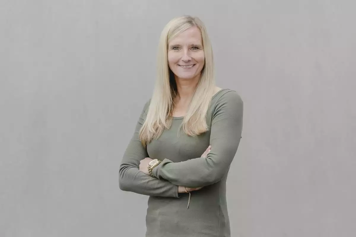 Eine frau, die vor einer grauen wand steht.