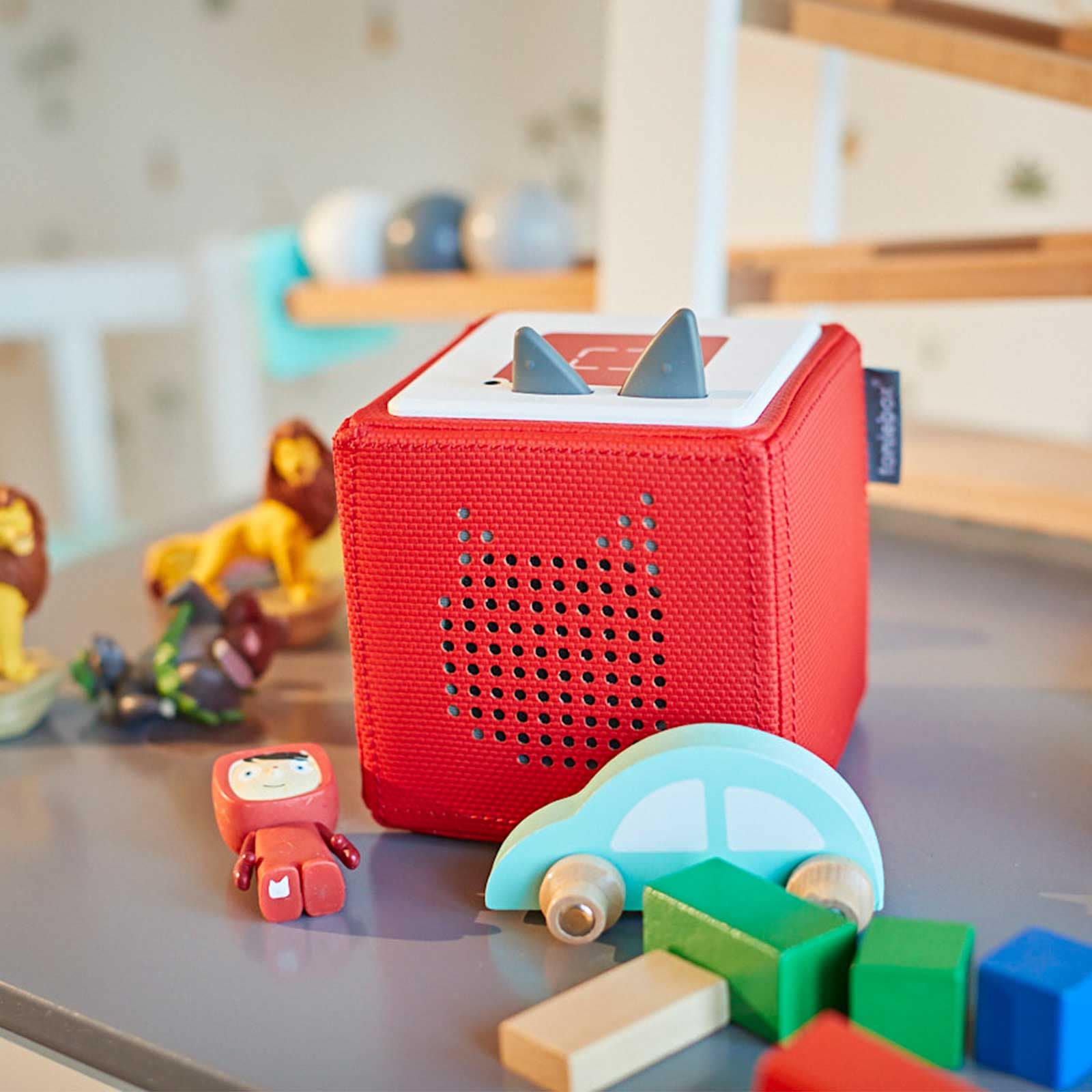 Korb ein roter auf einem tisch mit spielzeug darauf.