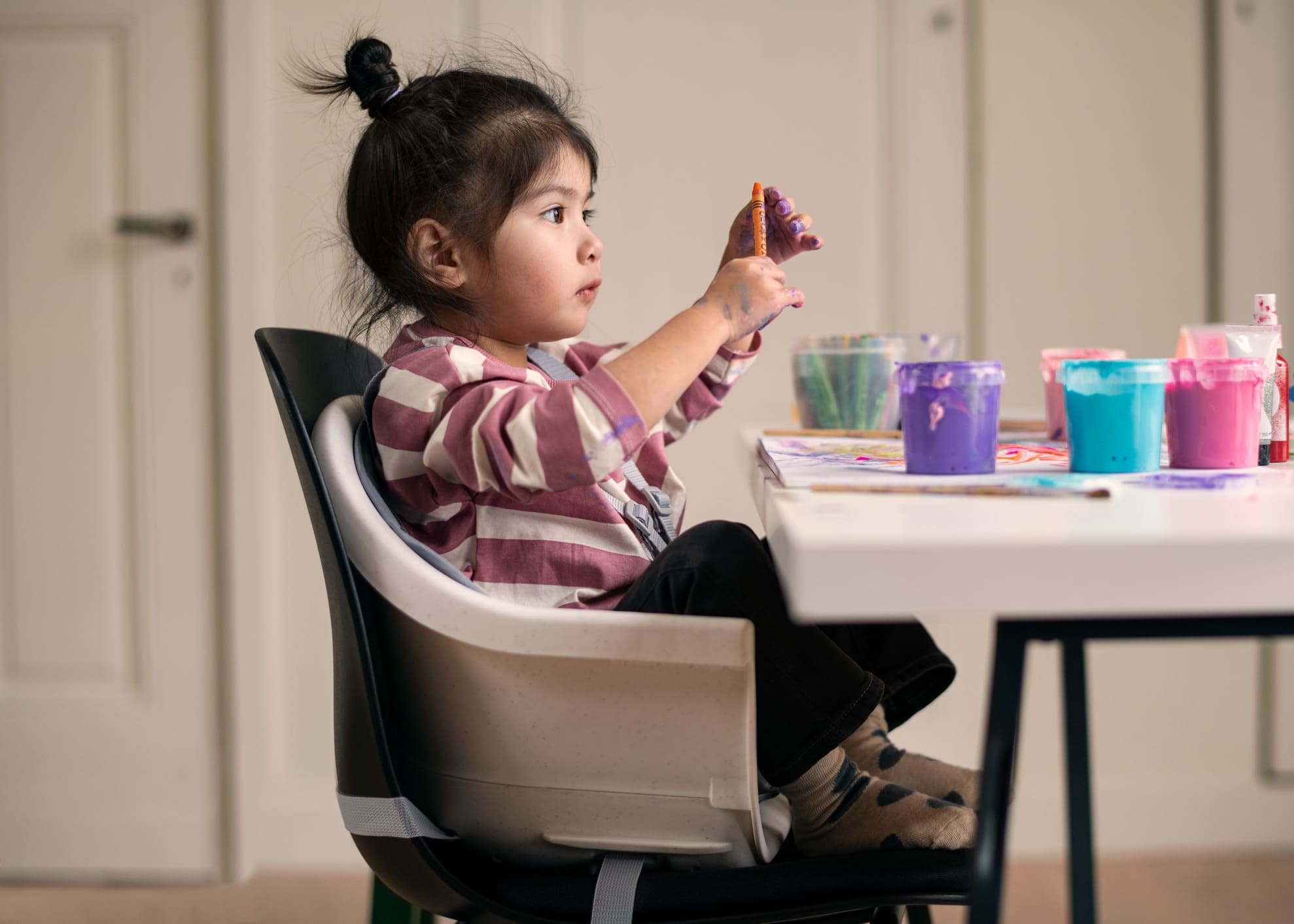 Ein mädchen kleines, das auf einem hochstuhl sitzt.