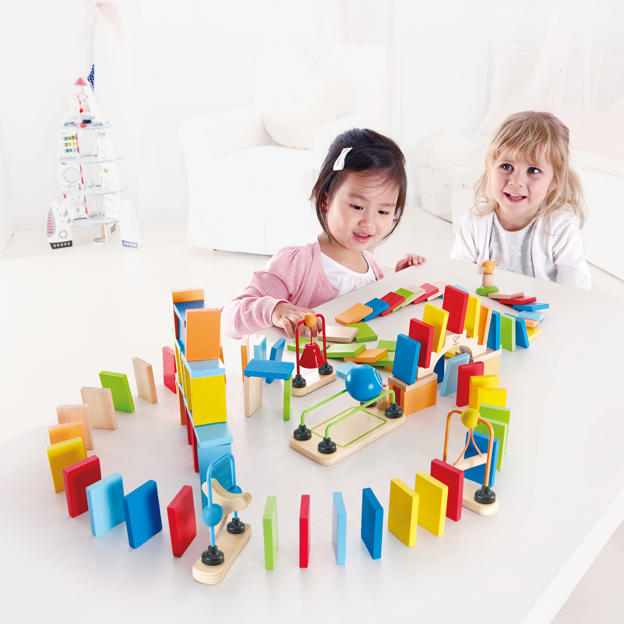 Puzzle, Hape, Mehrfarbig – Besonderheit: mit 100 Holzdominosteinen sowie einer Brücke, einer Glocke und einem Geländer