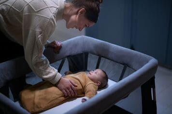 Eine frau, die ein baby auf einem hochstuhl hält.