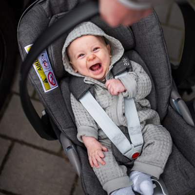 Baby ein auf einem autositz mit offenem mund.