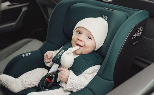 Baby ein auf einem autositz mit einem ausgestopften tier.
