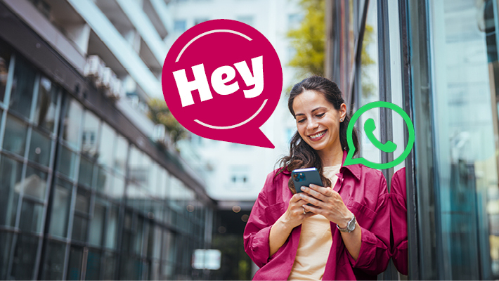 Frau schaut auf ihr Handy - Symbol Whats App