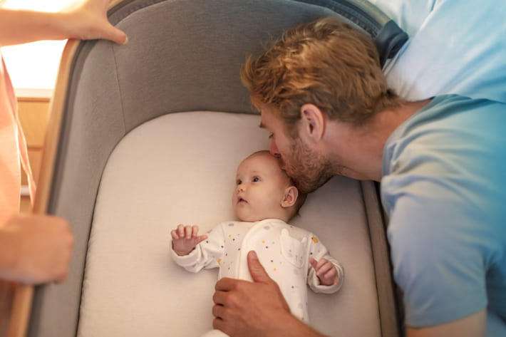 Ein mann, der ein baby in seinen armen hält.