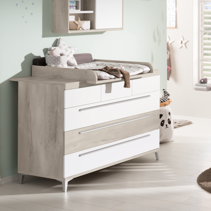 Babyzimmer ein mit einer weißen kommode und einem teddybär.