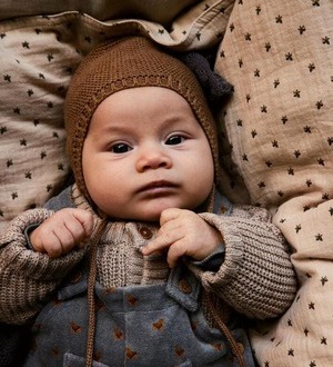 Ein Baby trägt eine braune Mütze.
